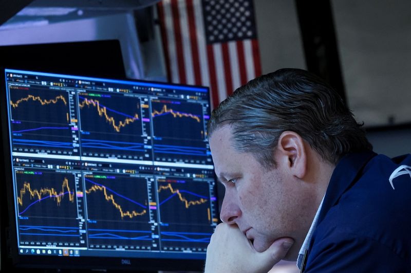 arafed man looking at a computer screen with a stock chart on it